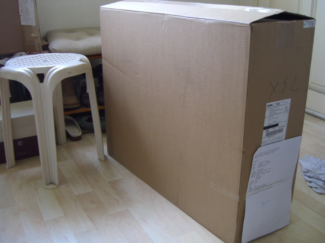a large cardboard box sitting next to a small stool