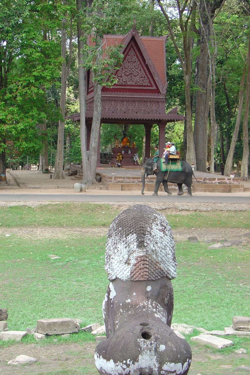 a statue sits in the grass beside a park
