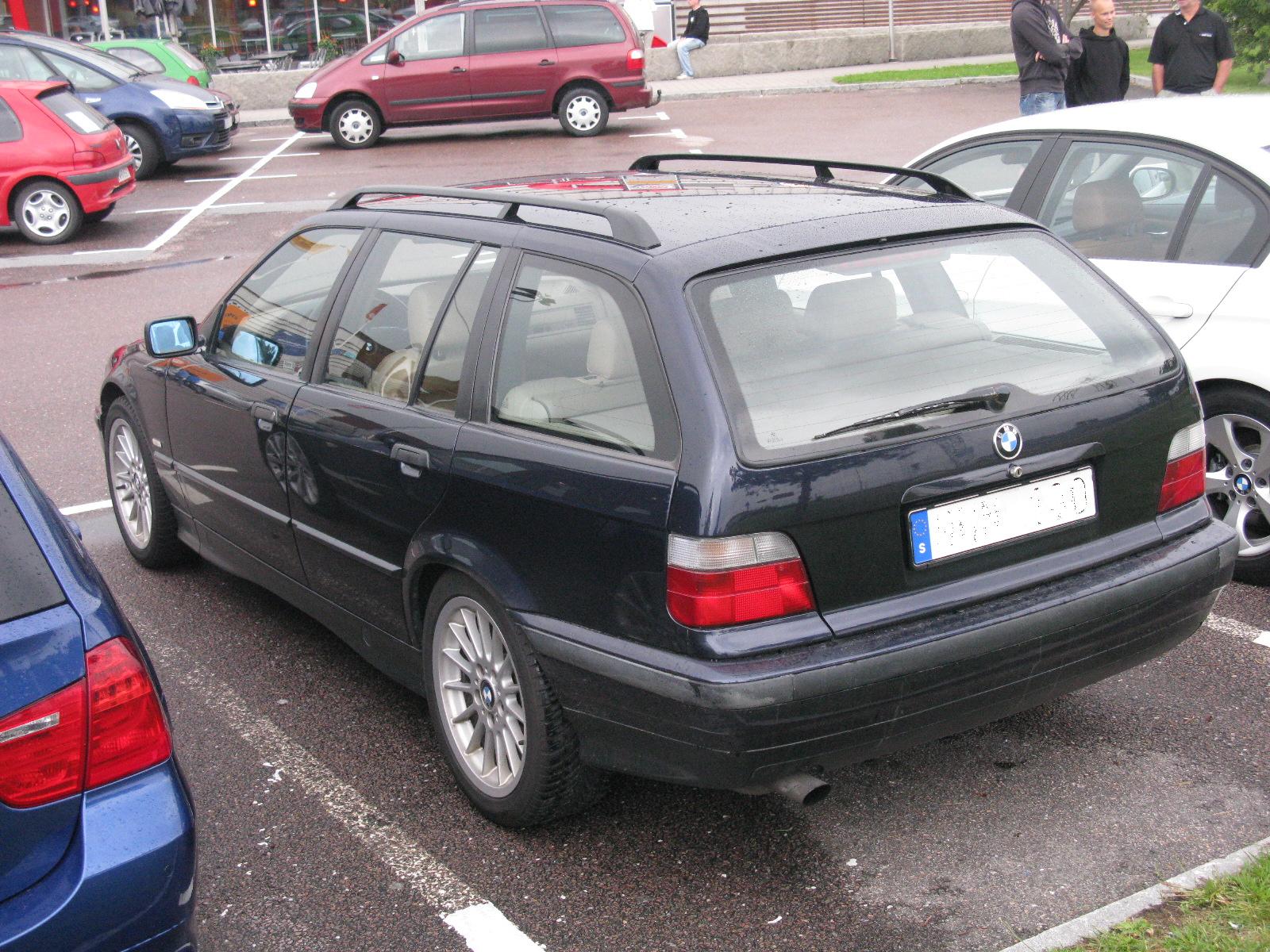 a black car sitting next to a white car in a parking lot