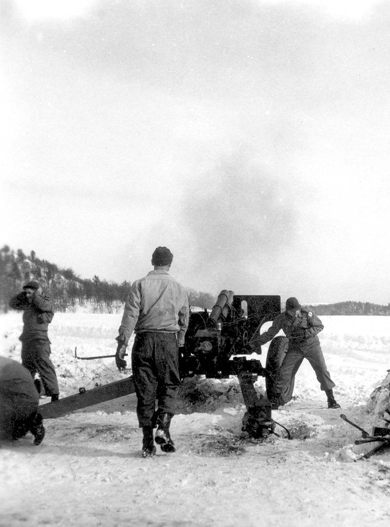 men are moving their truck over an icy field