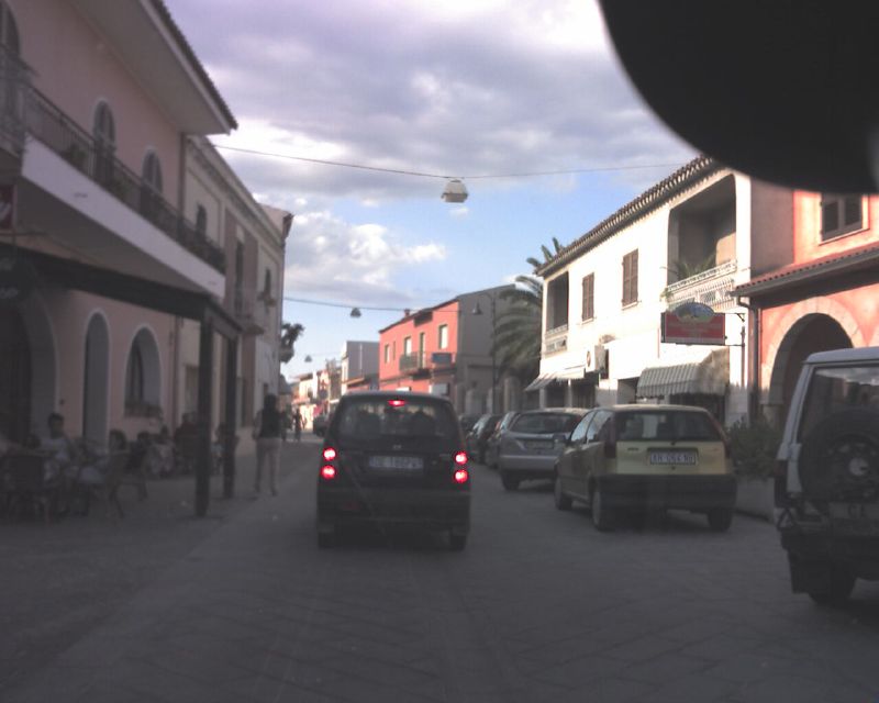 a car and two cars are on a street in a town