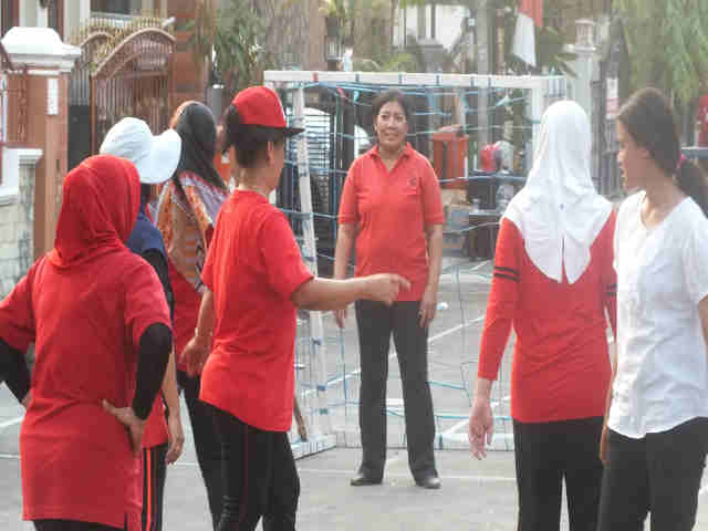 a group of women in red shirts playing frisbee