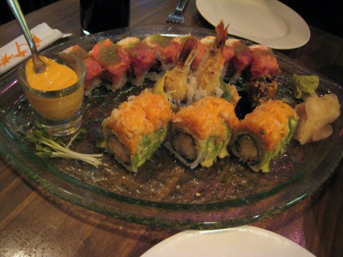 there is a large sushi plate with shrimp and avocado