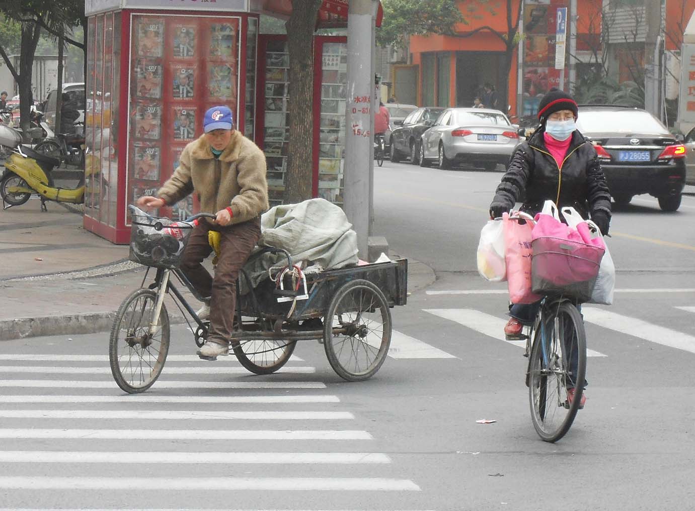 the man is riding his bike with two bags on the back