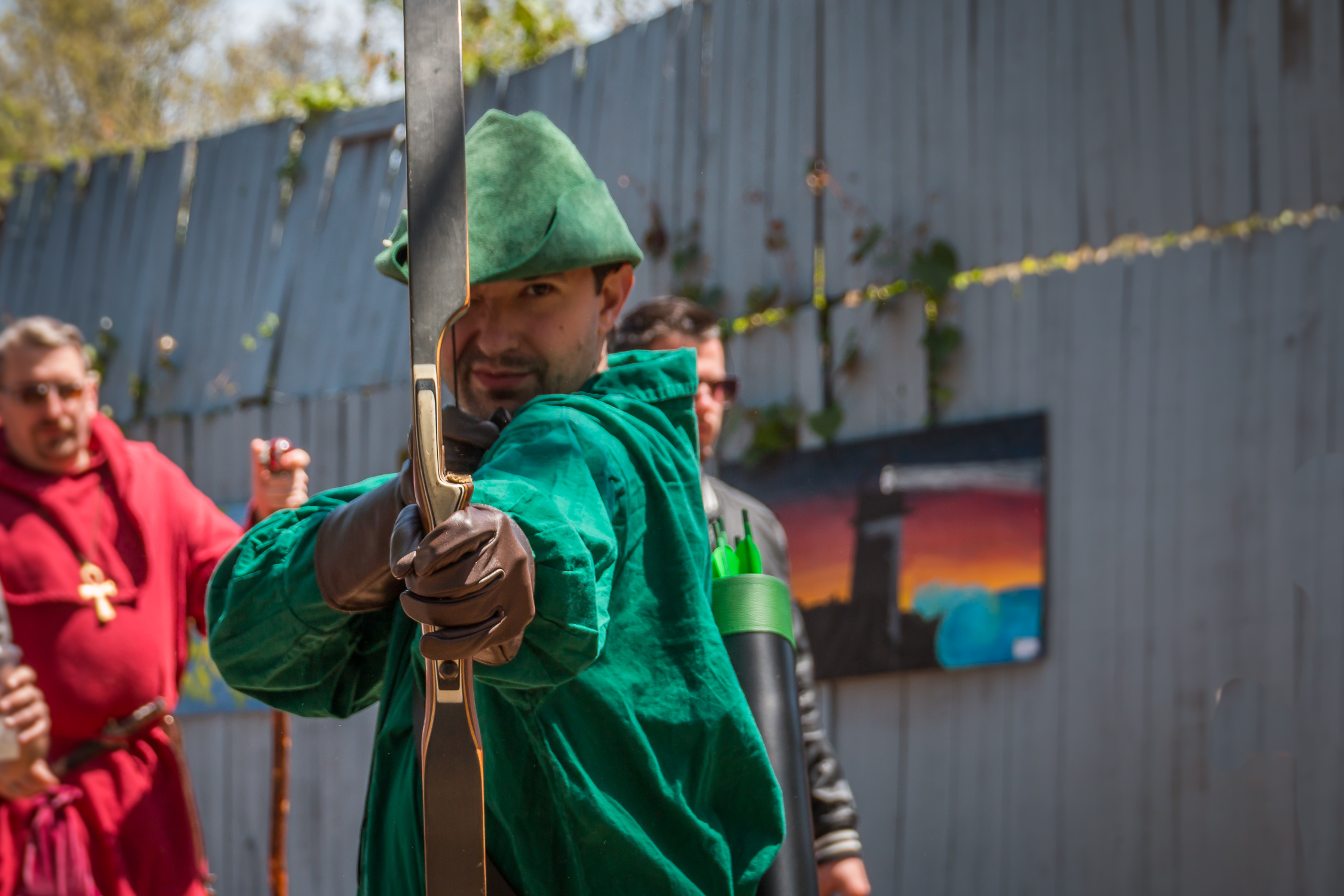 some people wearing green robes and holding up weapons