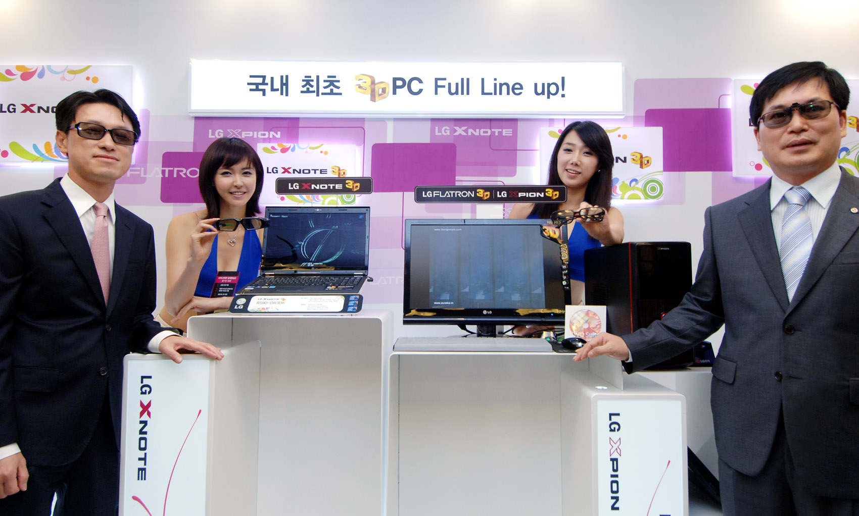 three asian people pose in front of the electronic computers