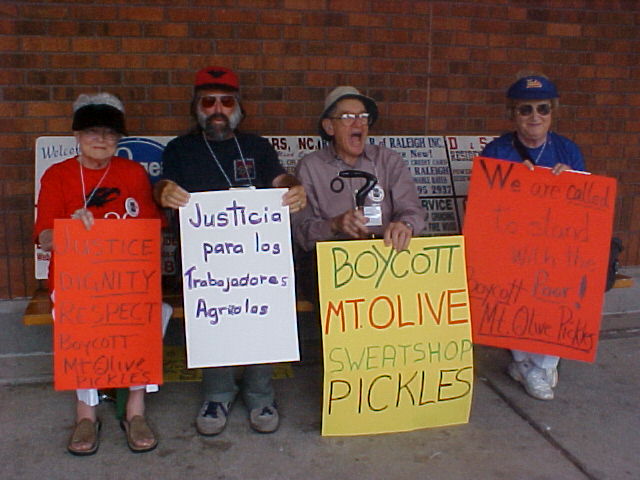 the four people on the bench are holding signs