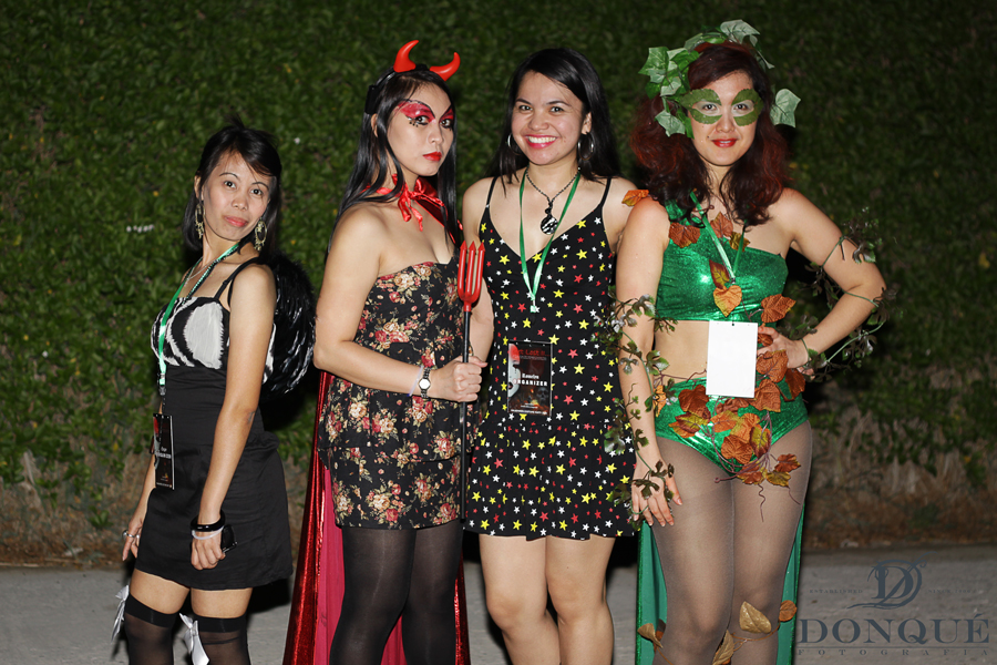 four women standing beside one another at a costume party