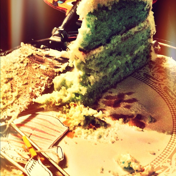 a green cake is sliced and on a plate