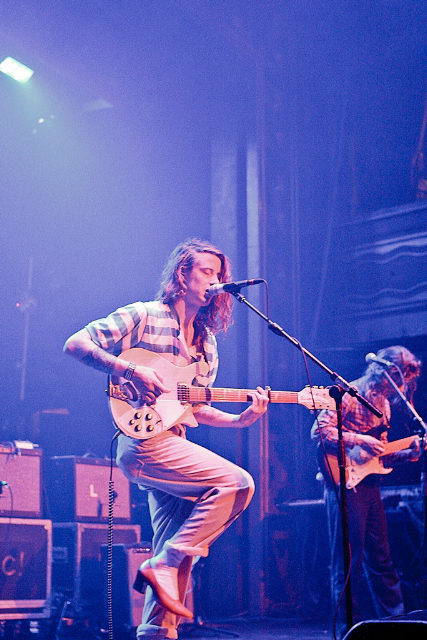 a male in a white shirt and some guitars
