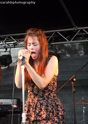 a woman holding a microphone up while performing