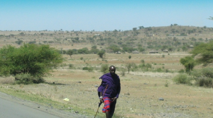 a person hiking down a road in the middle of nowhere