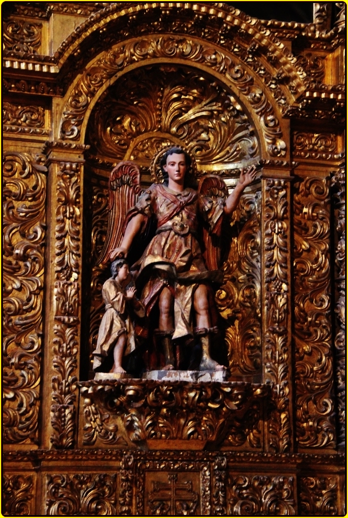 a statue in front of a golden wall