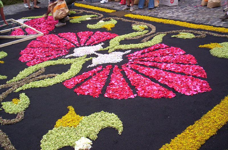a carpet with flowers on it with people watching