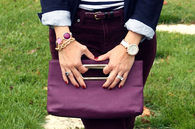 the woman is holding a purse outside with her hands on the handle