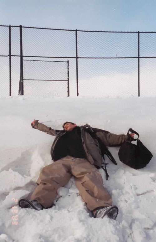 a person is laying in the snow with a backpack