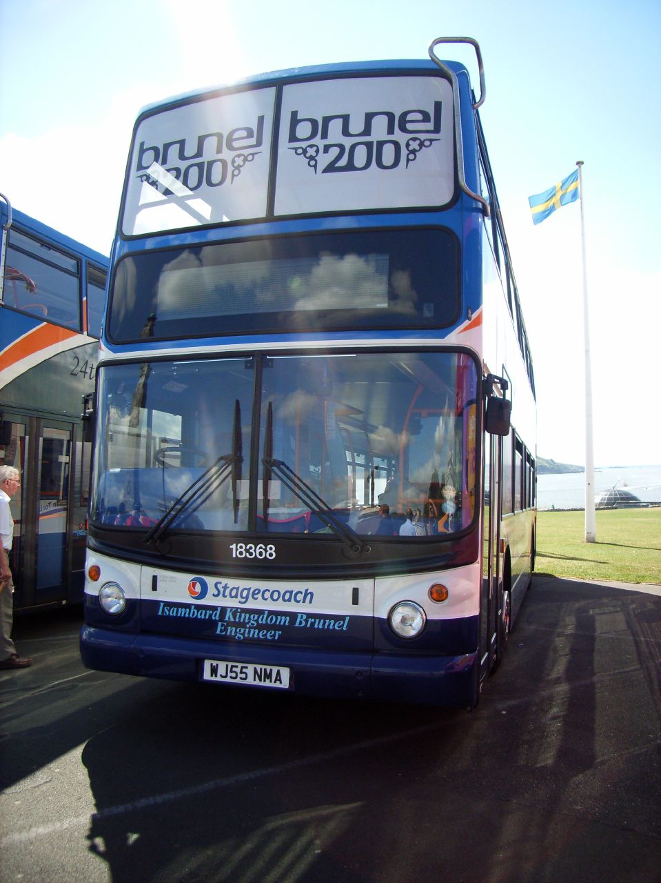 an orange white and blue double decker bus on street