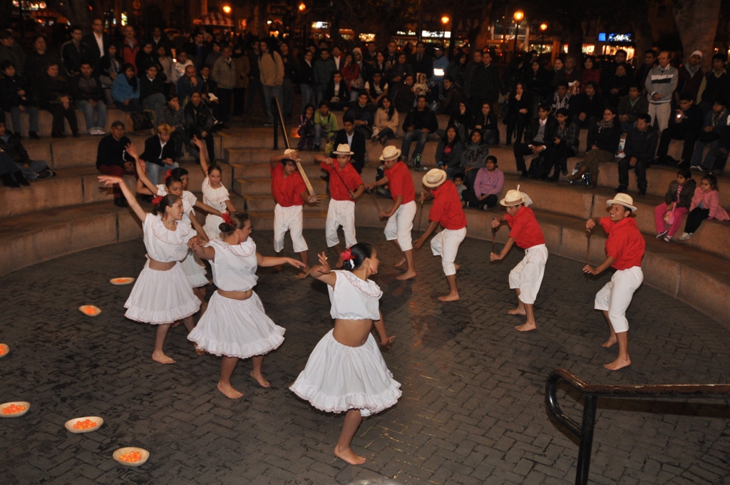 a group of people in white skirts dancing around