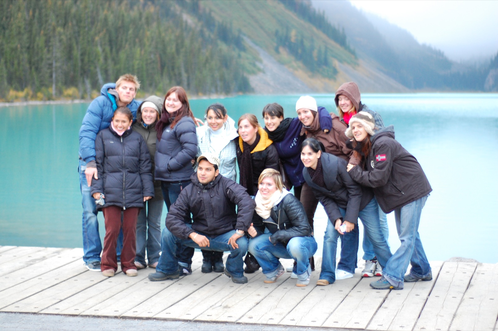 a group of people posing in front of a lake
