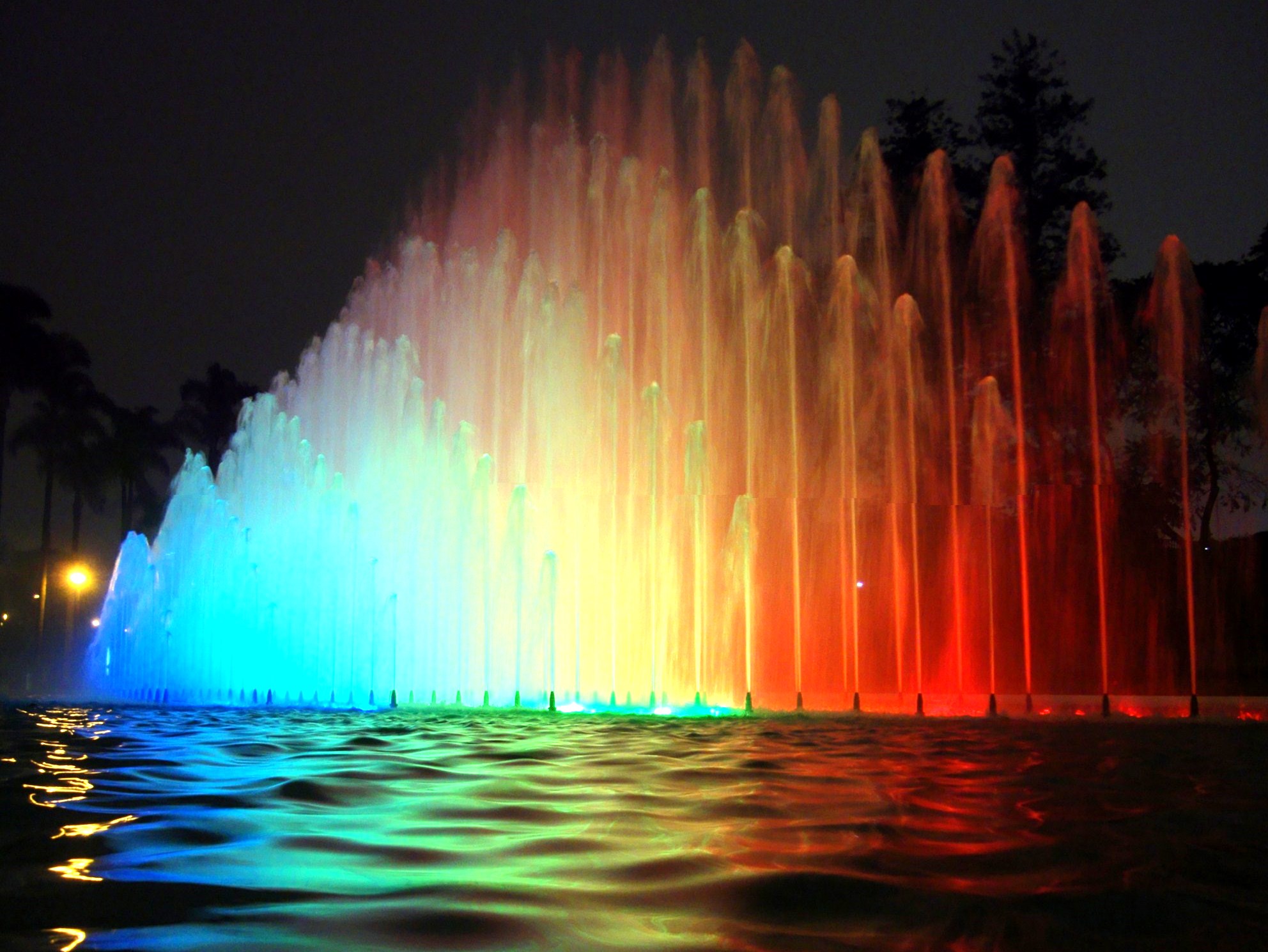 a fountain with lights and water spilling out of it