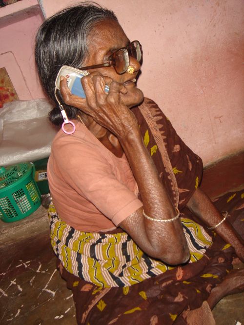 an old lady sitting on the floor and talking on her cell phone