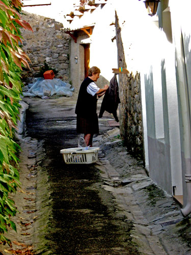 a woman standing next to a wall holding a bucket