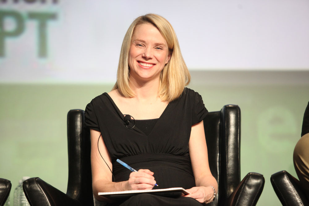 the woman is smiling while sitting on a chair