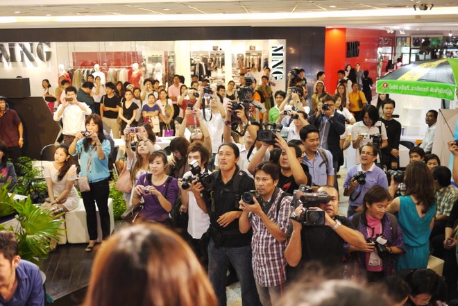 a large crowd of people taking pictures in a lobby