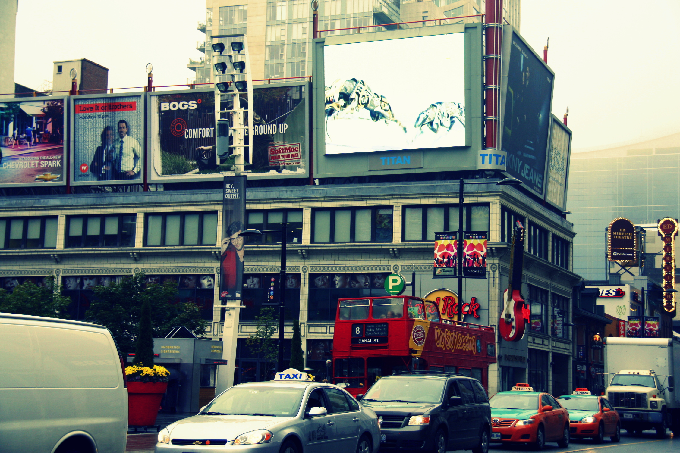 a city street full of traffic and people on tall buildings