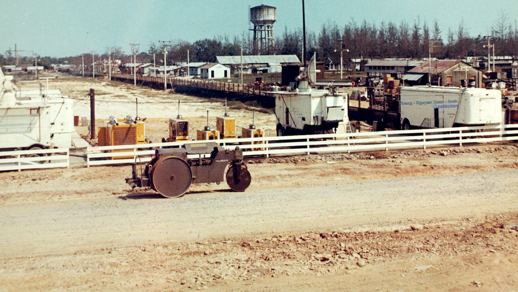 an old pograph of a rural village with trucks