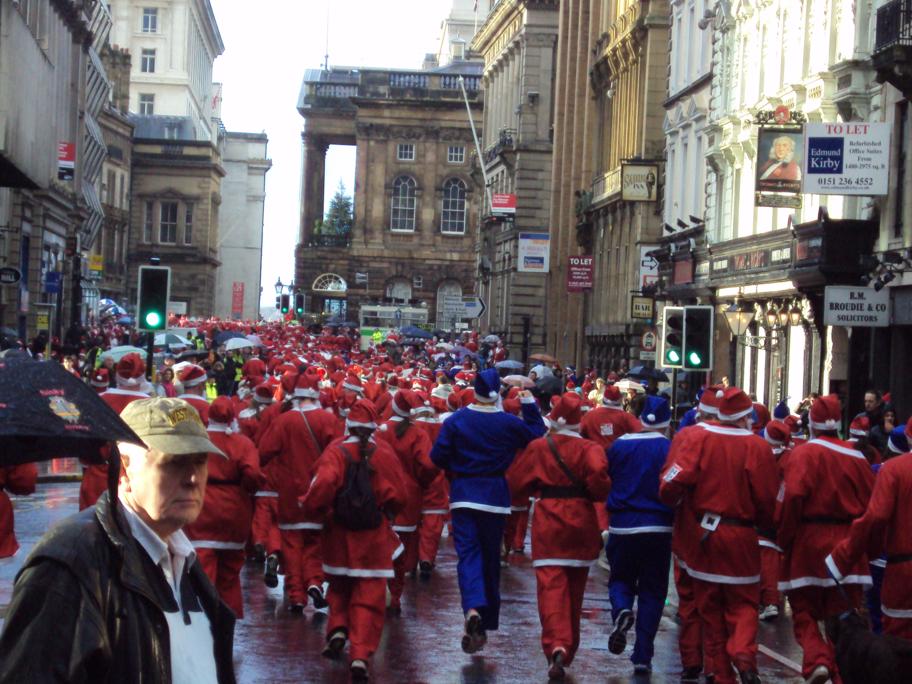 people in red and blue clothes and a man in black jacket walking down the street