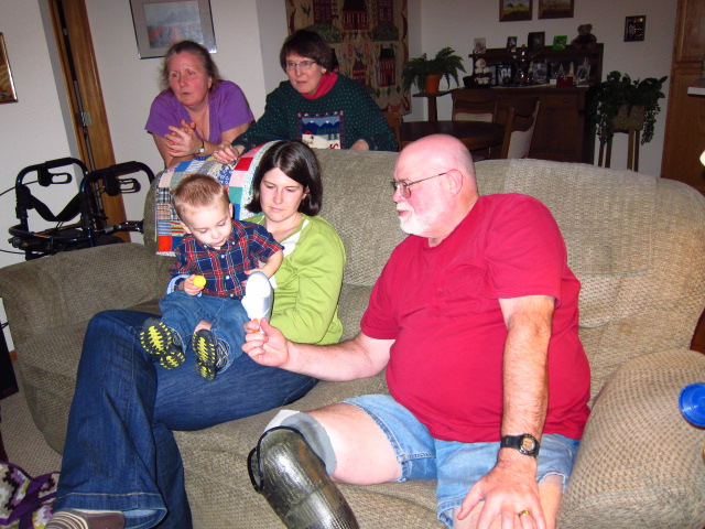 people sitting on a couch, with one sitting in the middle and holding a little boy