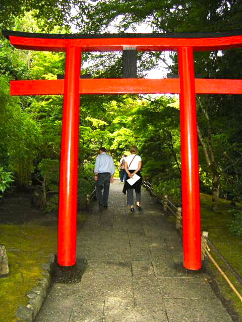 two people are walking in front of a red structure