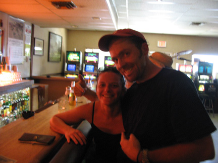 a couple poses at a bar and smiles for a picture