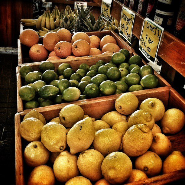 assorted produce sitting in wooden boxes on a display