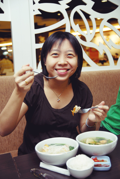 a woman is holding a fork and eating from a bowl