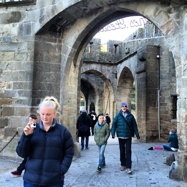 a group of people walking and jogging near an archway