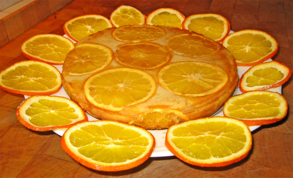 some sliced oranges sit on the table next to a dessert