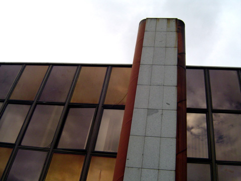 the outside of a large building, that looks up into a cloudy sky