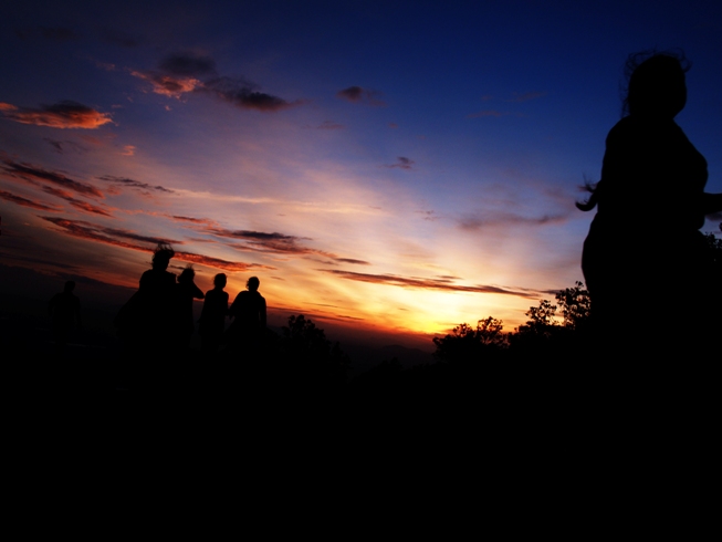 silhouettes of four people against a dusk sky