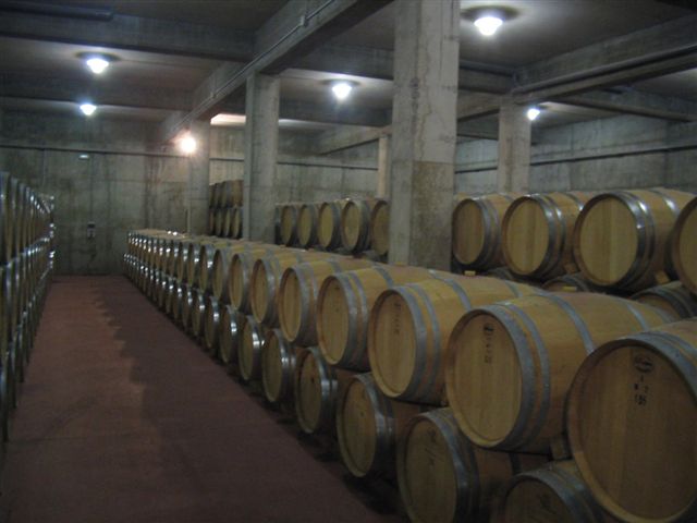 many wooden barrels are stacked up in a room