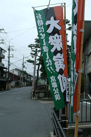 several banners hanging over a sidewalk near buildings