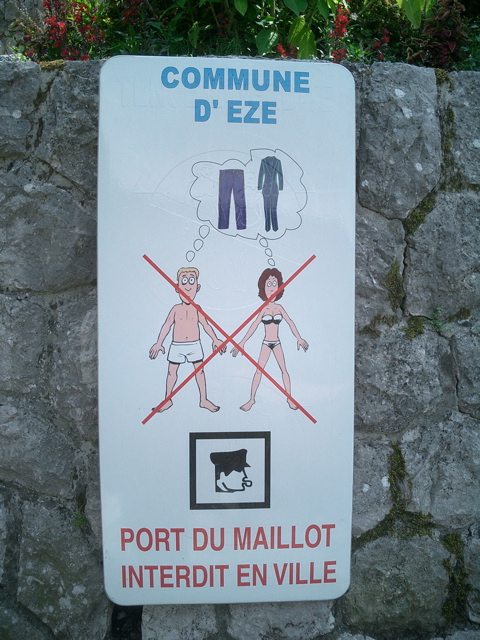 a sign on a stone wall warns people to keep their shoes in
