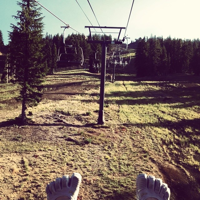 someone standing under a ski lift holding their feet up