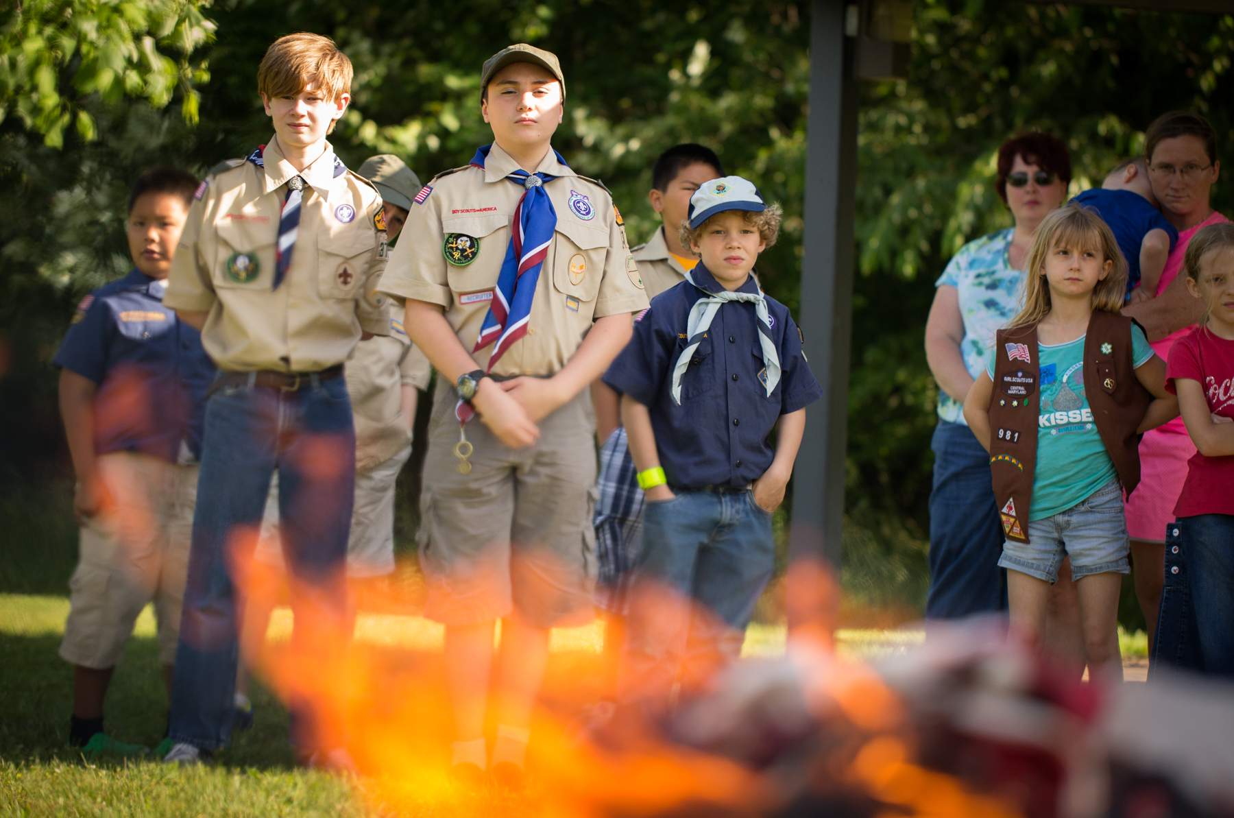 a group of children and adults standing near a fire