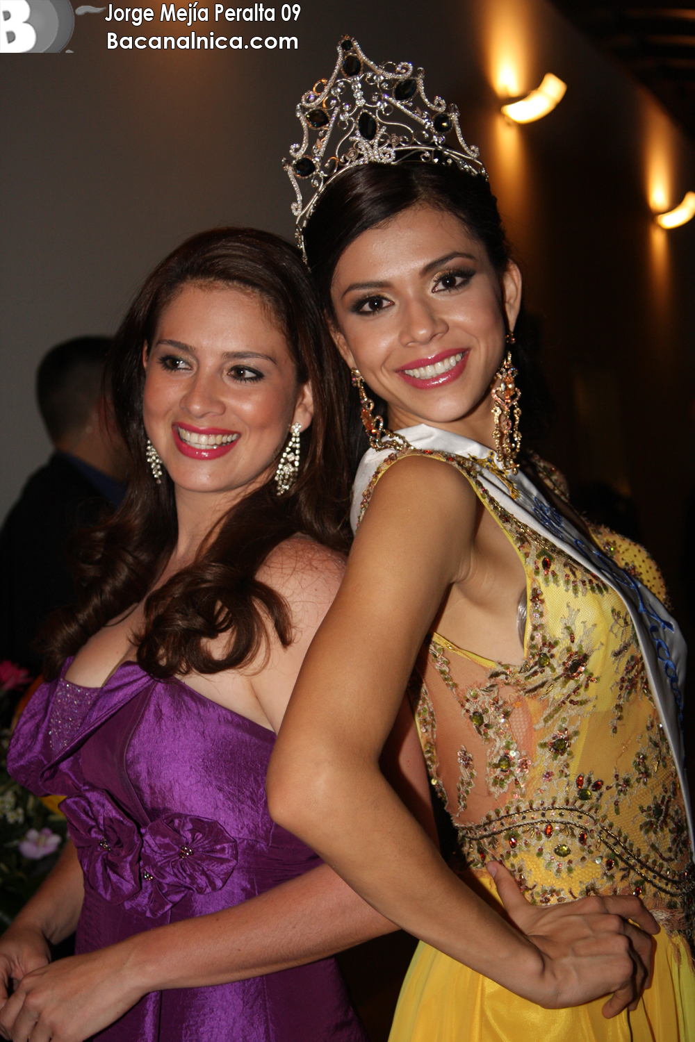 two beautiful young women dressed in gowns and tiaras