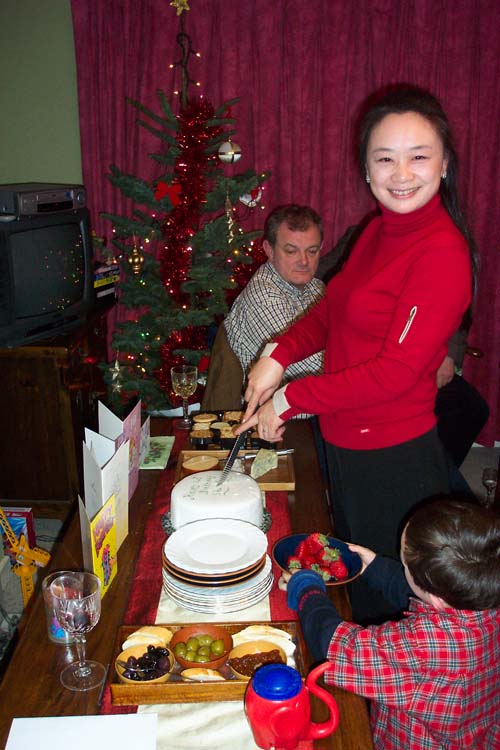 people standing around a table and  a cake