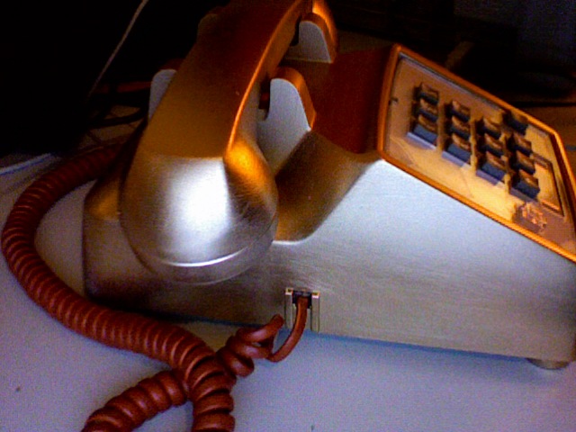 a very weird looking old fashioned telephone is sitting on the desk