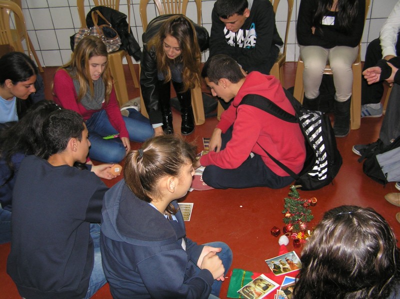 a group of young people gathered around a table playing games