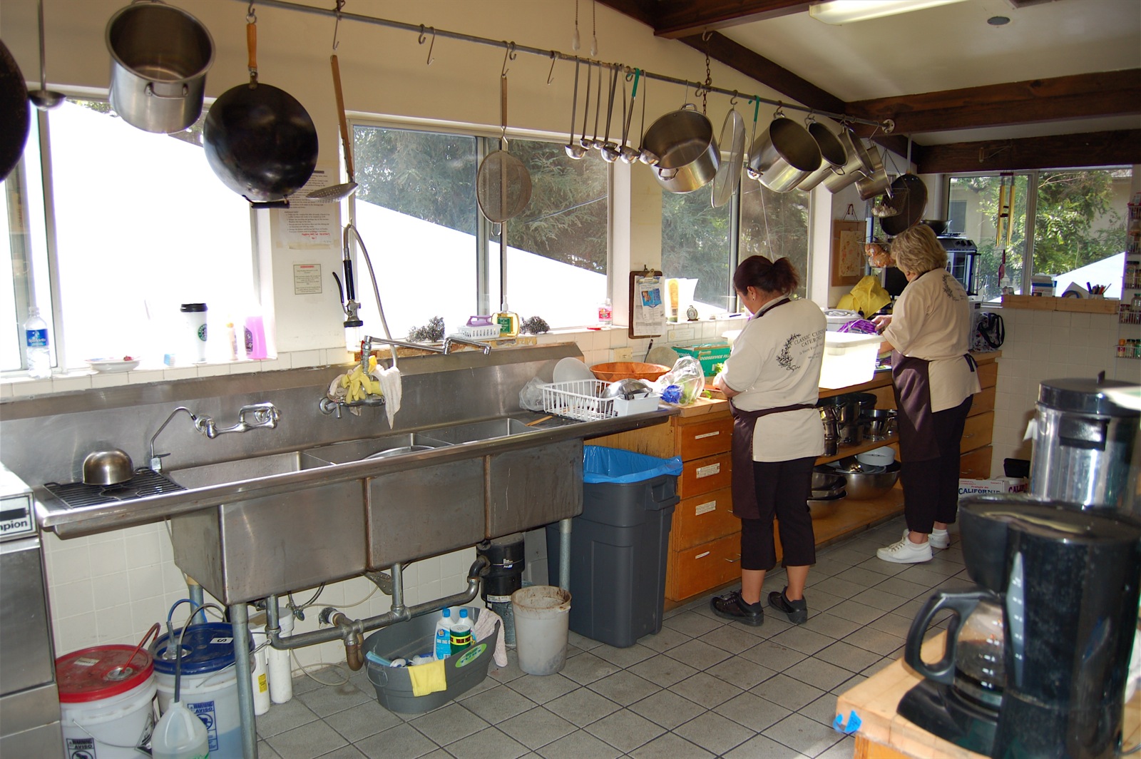 two women stand in front of an open kitchen